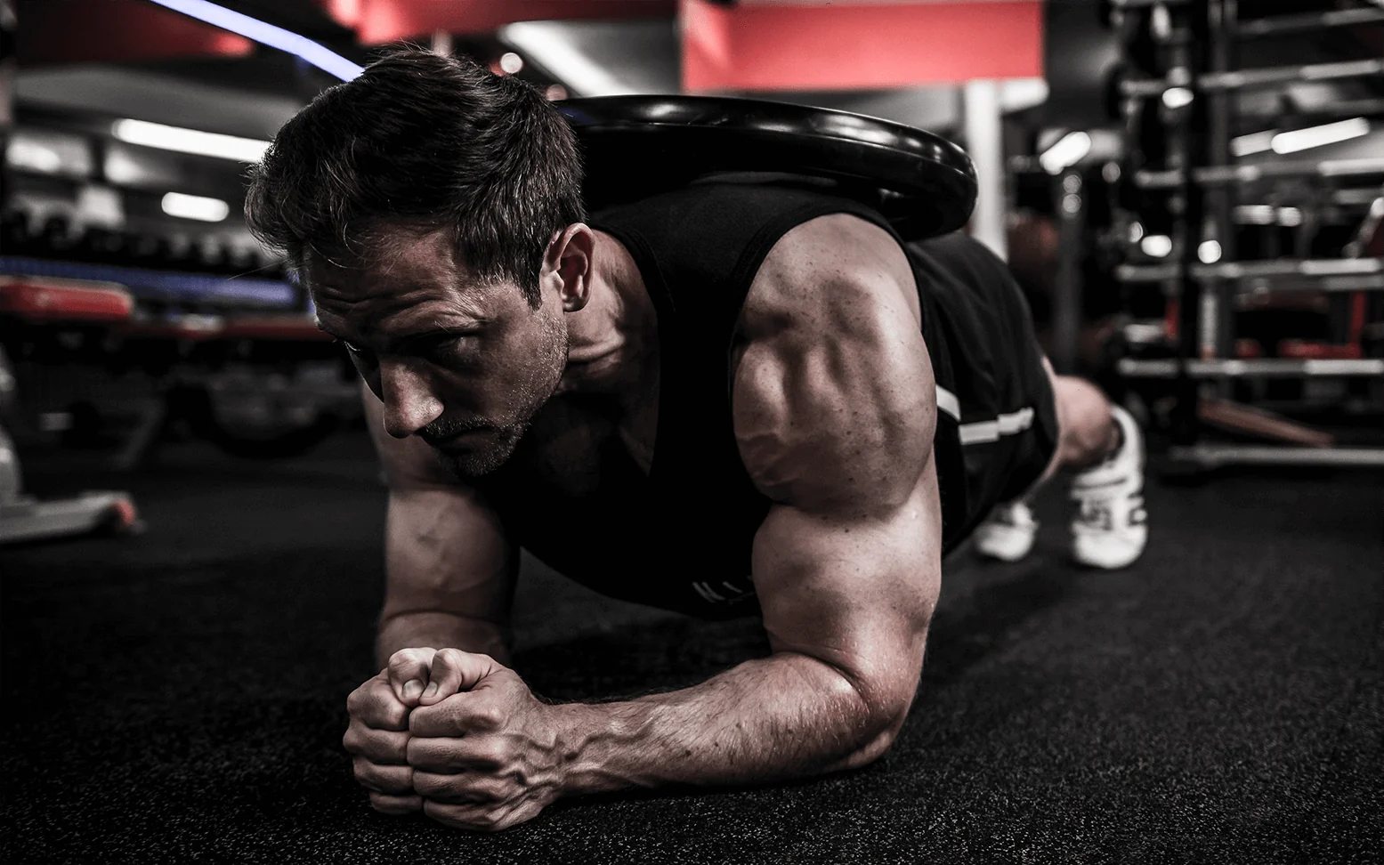 Jonny holding a weighted forearm plank during a workout